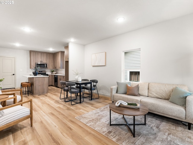 living area featuring recessed lighting, light wood-style floors, and baseboards