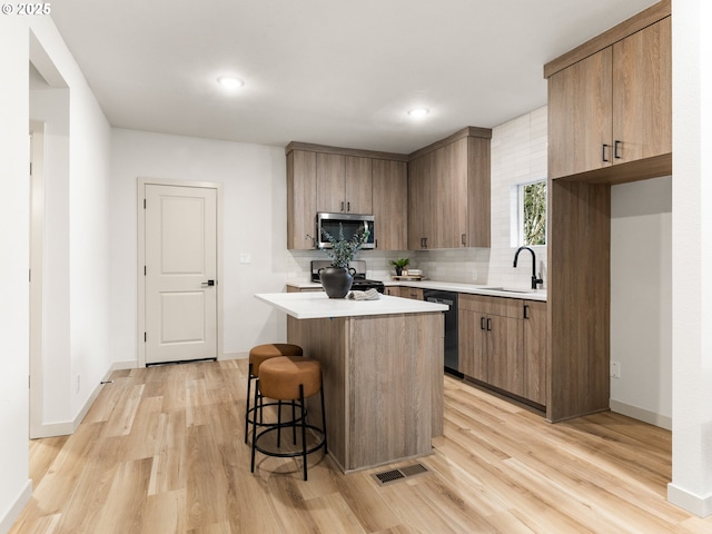 kitchen with dishwashing machine, visible vents, a sink, stainless steel microwave, and range