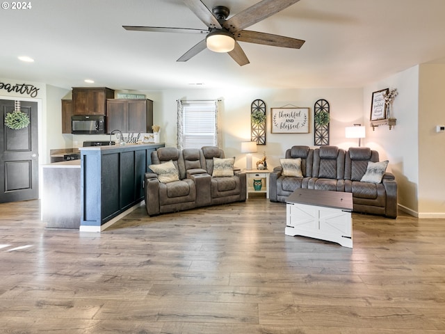 living room with wood-type flooring and ceiling fan