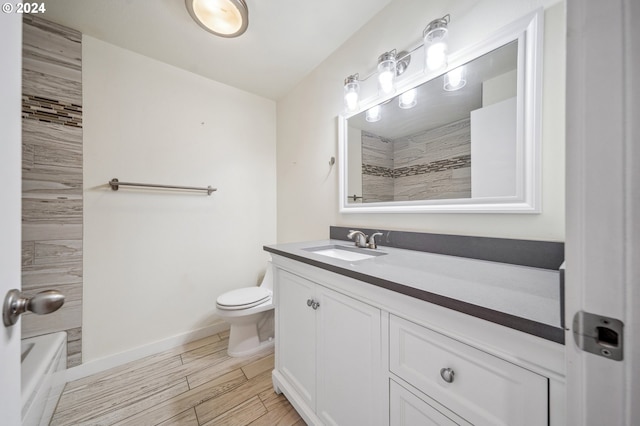 bathroom featuring wood-type flooring, toilet, and vanity