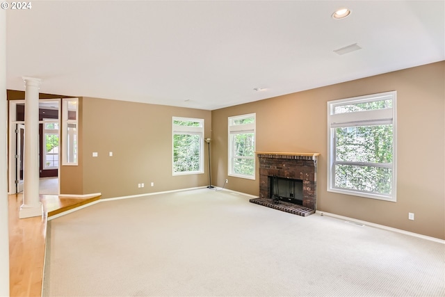 unfurnished living room with a fireplace, carpet, and a wealth of natural light