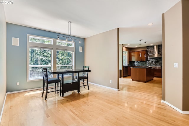 dining area with sink and light wood-type flooring