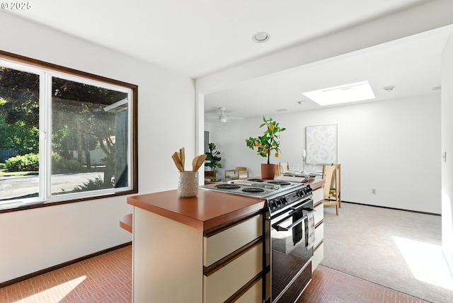 160 Beatrice Ave, Gladstone, OR 97027 - kitchen featuring black range with electric stovetop, light colored carpet, a skylight, dark countertops, and recessed lighting