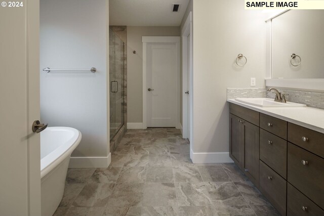 bathroom with shower with separate bathtub, large vanity, and tile flooring