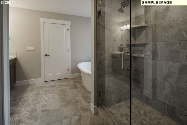 bathroom featuring tile floors, separate shower and tub, and vanity