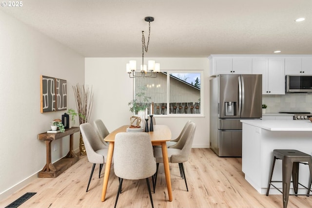 dining space featuring visible vents, baseboards, light wood-style flooring, recessed lighting, and a notable chandelier