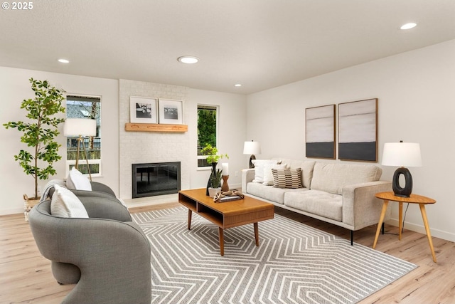 living area featuring recessed lighting, wood finished floors, and a fireplace