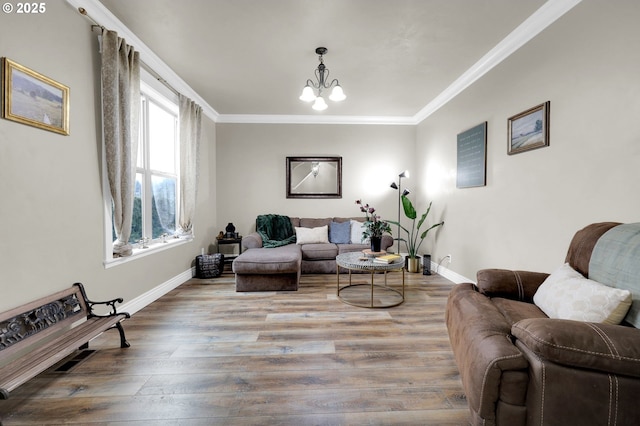 living room with an inviting chandelier, wood-type flooring, and ornamental molding