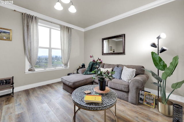 living room featuring hardwood / wood-style flooring, ornamental molding, and a chandelier