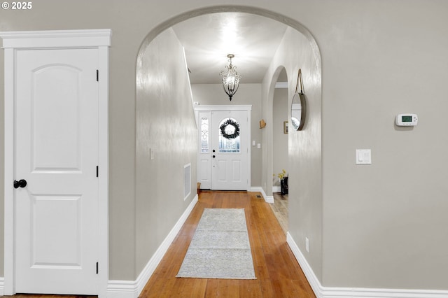 doorway to outside featuring hardwood / wood-style flooring and a chandelier