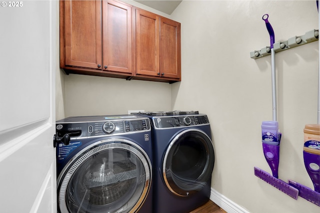 clothes washing area with cabinets and washing machine and dryer