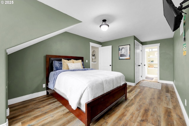 bedroom featuring hardwood / wood-style flooring and ensuite bath