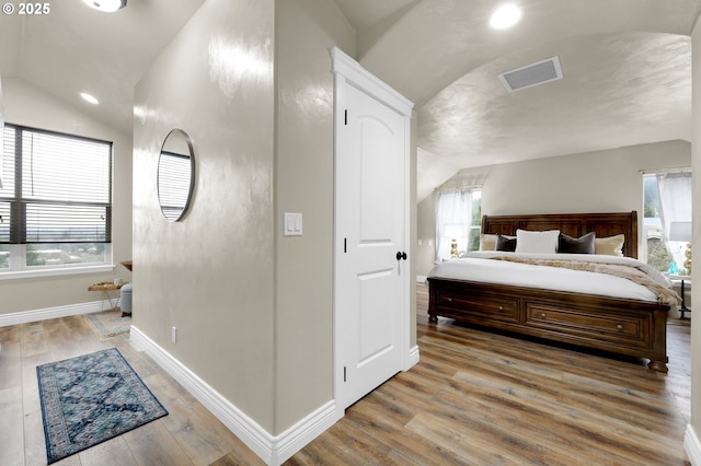 bedroom featuring light hardwood / wood-style flooring and vaulted ceiling