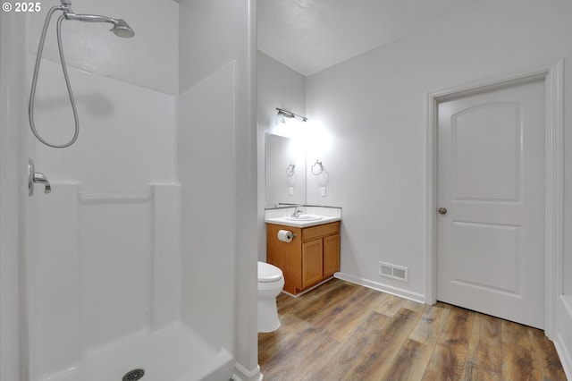 bathroom with vanity, hardwood / wood-style floors, toilet, and walk in shower