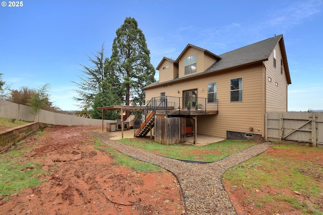 rear view of property featuring a wooden deck and a patio