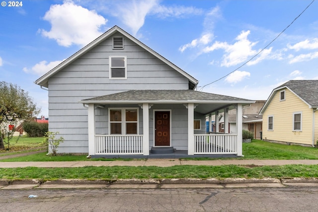 view of front of property featuring covered porch and a front lawn