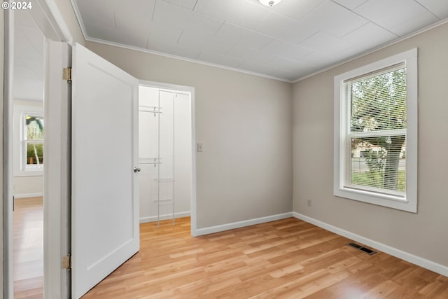 spare room featuring ornamental molding and light hardwood / wood-style floors