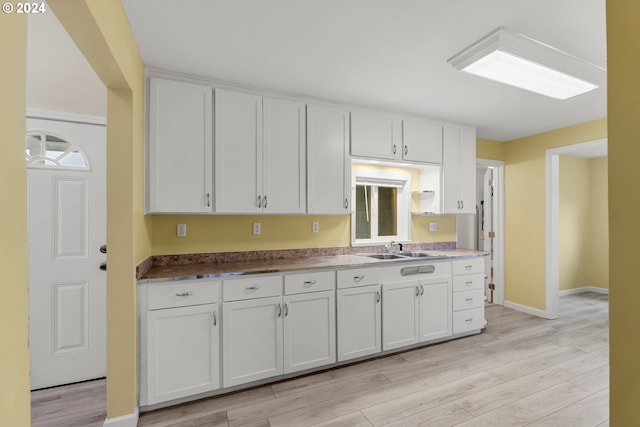 kitchen featuring sink, white cabinets, and light wood-type flooring