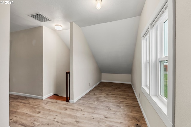 bonus room featuring light hardwood / wood-style floors and vaulted ceiling