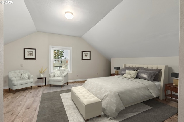 bedroom with wood-type flooring and vaulted ceiling