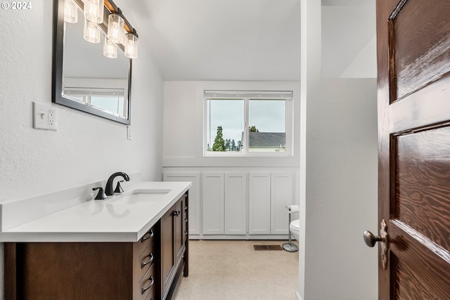 bathroom featuring vanity, toilet, and a healthy amount of sunlight