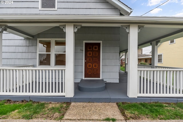 view of exterior entry featuring covered porch