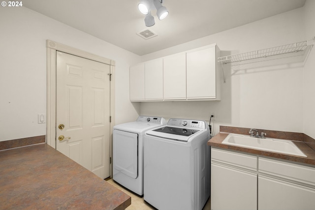 washroom featuring cabinets, separate washer and dryer, and sink