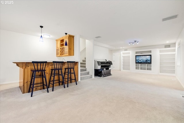 interior space featuring light colored carpet, built in features, and bar