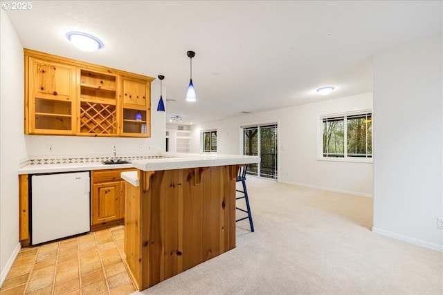 bar featuring refrigerator, light colored carpet, hanging light fixtures, and white dishwasher