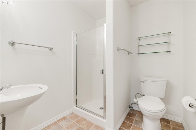 bathroom featuring sink, an enclosed shower, and toilet