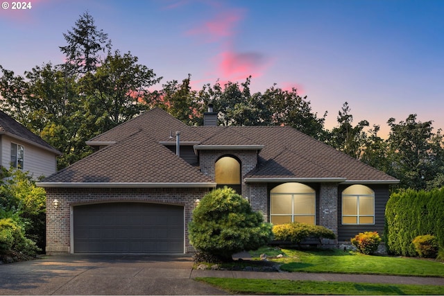 view of front facade with a yard and a garage