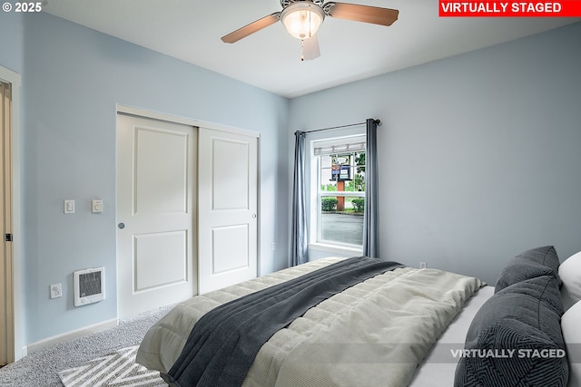 carpeted bedroom with heating unit, a closet, and ceiling fan