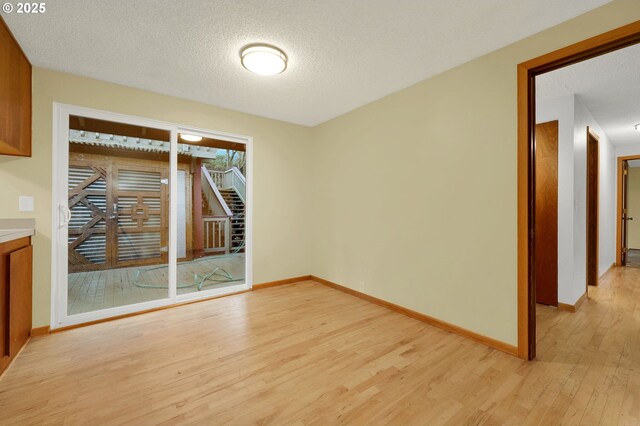 spare room featuring a textured ceiling and light wood-type flooring