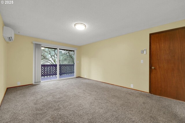 carpeted empty room featuring a textured ceiling and an AC wall unit