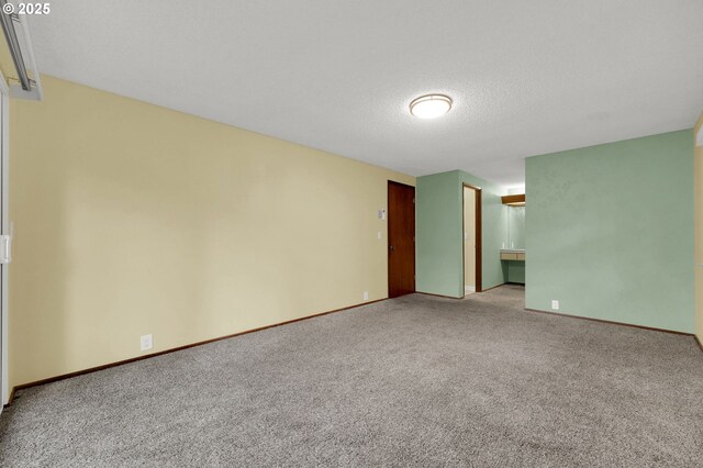 carpeted spare room with a textured ceiling