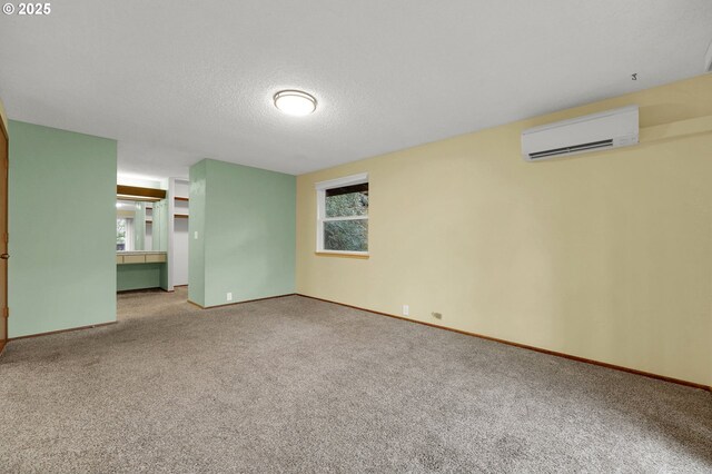 unfurnished room featuring a wall mounted AC, carpet, and plenty of natural light