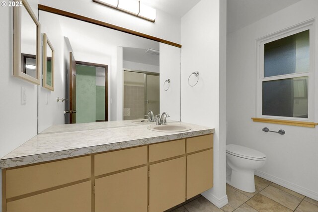 bathroom with toilet, a shower with door, vanity, and tile patterned flooring