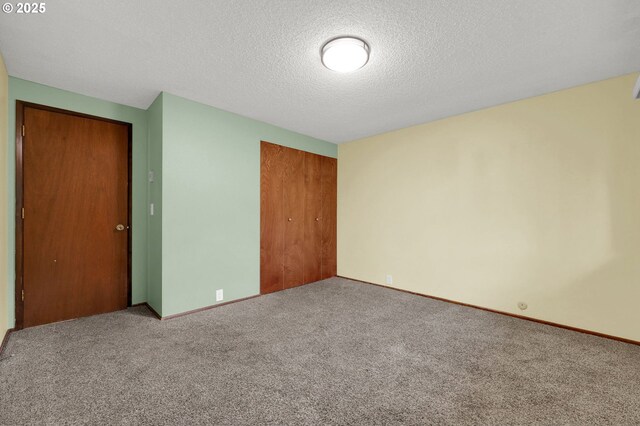 unfurnished bedroom with a textured ceiling, a closet, and carpet floors