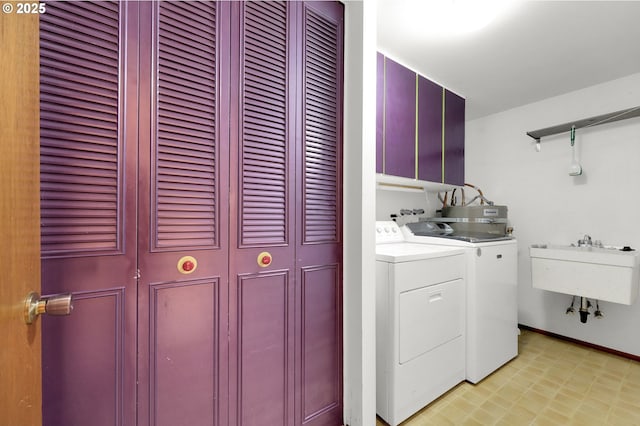 laundry room featuring cabinets, washer and clothes dryer, and sink