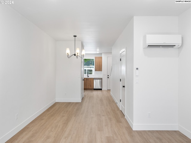 interior space featuring an inviting chandelier, light wood-type flooring, and a wall mounted AC