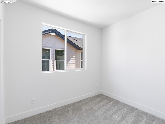 carpeted spare room featuring lofted ceiling