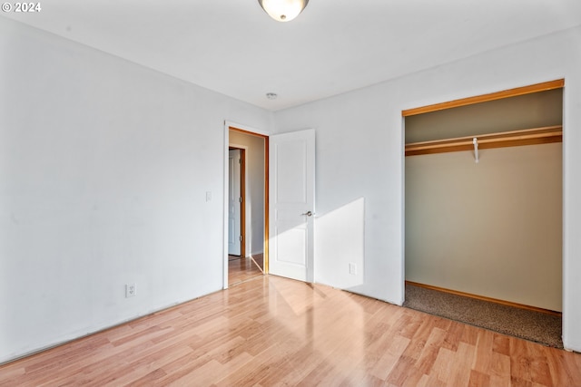 unfurnished bedroom with a closet and light hardwood / wood-style floors