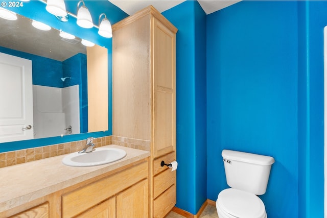 bathroom featuring a shower, vanity, and toilet