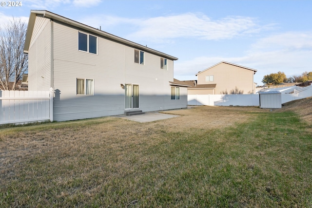 rear view of property featuring a yard and a patio area