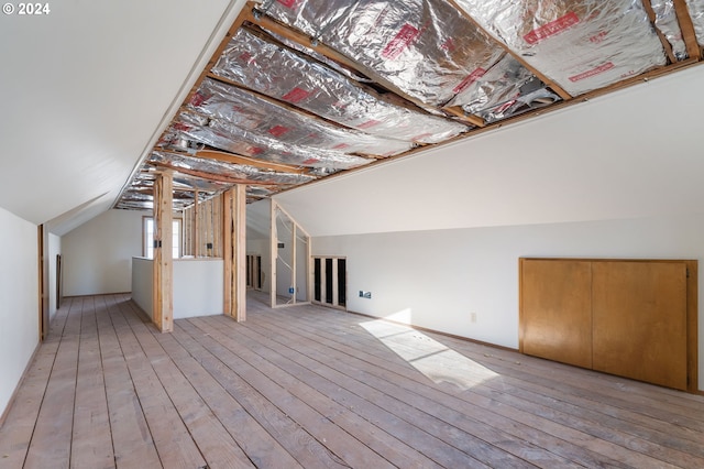 bonus room featuring lofted ceiling and light wood-type flooring