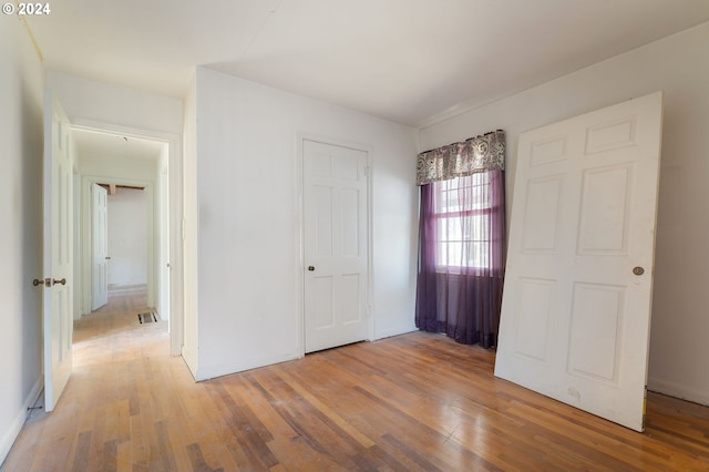 unfurnished bedroom with a closet and hardwood / wood-style floors