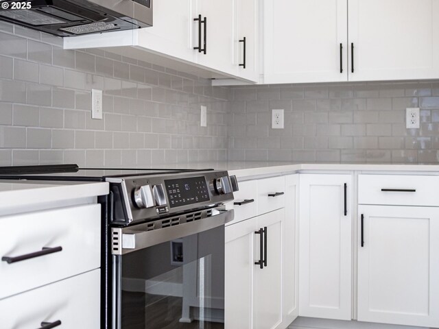 kitchen featuring sink, white cabinets, pendant lighting, light wood-type flooring, and appliances with stainless steel finishes