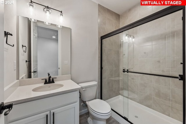 bathroom featuring vanity, toilet, and walk in shower