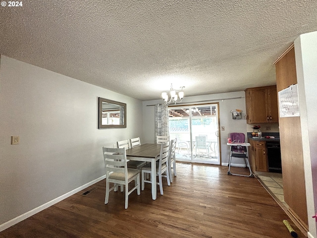 dining room with a textured ceiling, hardwood / wood-style floors, and a chandelier