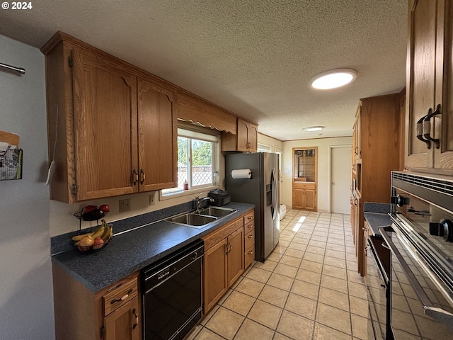 kitchen featuring appliances with stainless steel finishes, light tile patterned floors, a textured ceiling, and sink